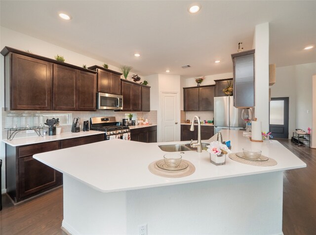 kitchen featuring tasteful backsplash, dark brown cabinets, stainless steel appliances, sink, and dark hardwood / wood-style floors