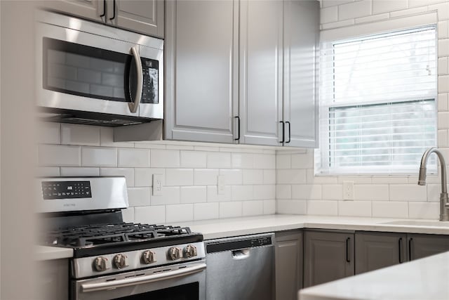 kitchen featuring gray cabinets, plenty of natural light, and stainless steel appliances