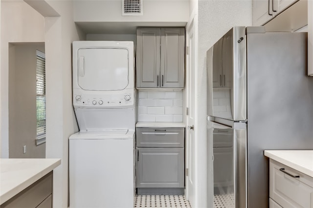 clothes washing area featuring stacked washer / drying machine