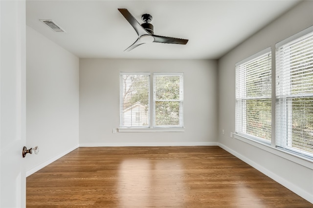 spare room with plenty of natural light, ceiling fan, and wood-type flooring