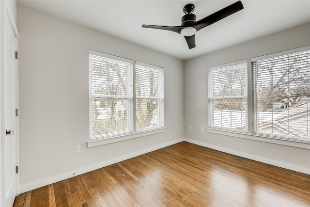 spare room featuring ceiling fan, a healthy amount of sunlight, and wood-type flooring