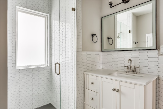 bathroom with vanity, an enclosed shower, and tile walls