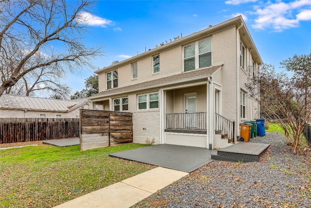 rear view of house featuring a lawn and a patio