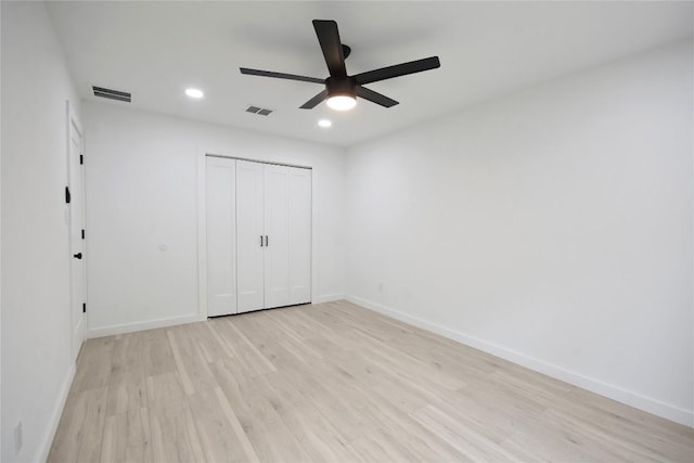 unfurnished bedroom with light hardwood / wood-style flooring, a closet, and ceiling fan