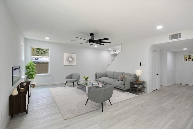 living room featuring light hardwood / wood-style flooring and ceiling fan