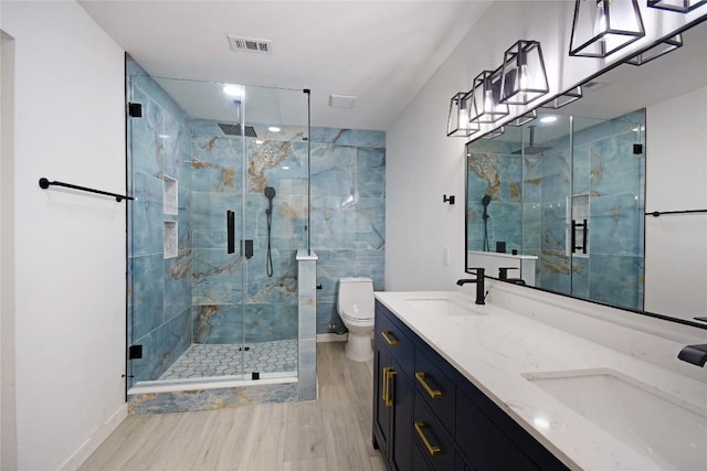 bathroom featuring walk in shower, vanity, toilet, and hardwood / wood-style flooring