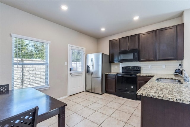 kitchen featuring backsplash, black appliances, sink, dark brown cabinets, and light stone counters