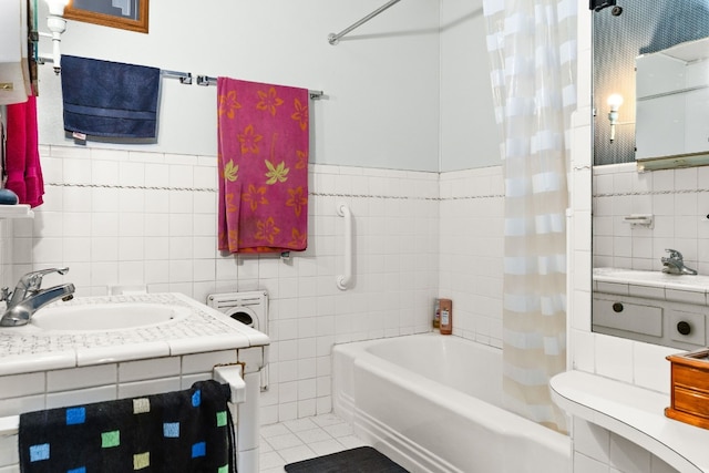 bathroom with tile patterned floors, shower / bath combo with shower curtain, sink, and tile walls