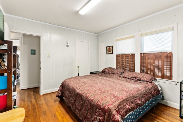 bedroom with wood-type flooring and ornamental molding