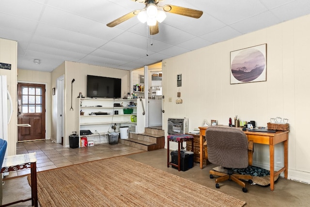 tiled office space featuring a paneled ceiling and ceiling fan