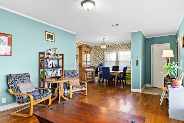 living area featuring hardwood / wood-style floors, an inviting chandelier, and ornamental molding