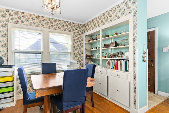 dining area with crown molding, hardwood / wood-style floors, and a notable chandelier