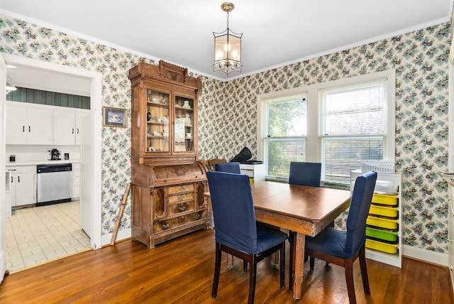 dining area with crown molding, a notable chandelier, and hardwood / wood-style flooring