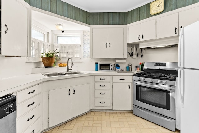 kitchen featuring appliances with stainless steel finishes, white cabinetry, crown molding, and sink