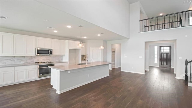 kitchen with dark hardwood / wood-style floors, white cabinetry, sink, and appliances with stainless steel finishes