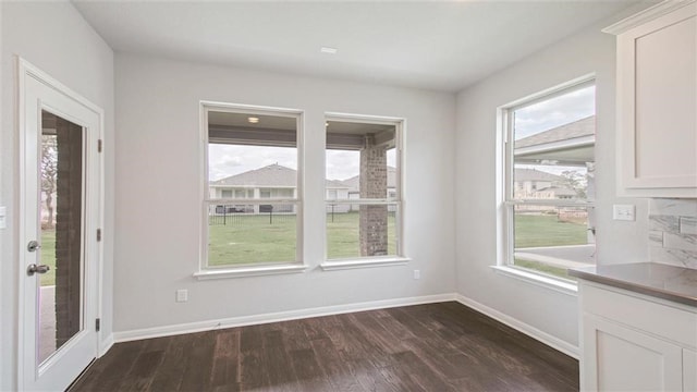 unfurnished dining area featuring dark hardwood / wood-style floors