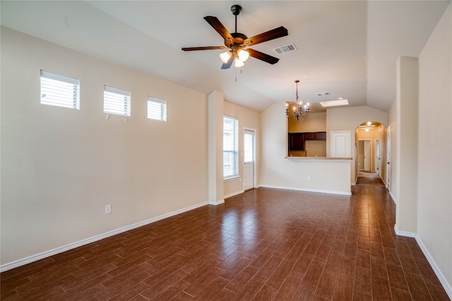 unfurnished living room with ceiling fan with notable chandelier, dark wood-type flooring, and vaulted ceiling