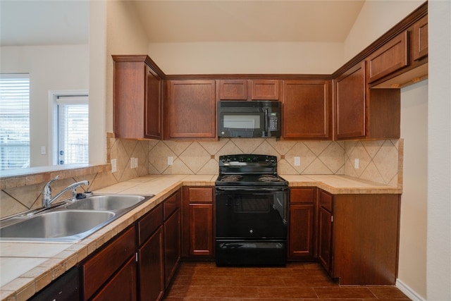 kitchen with backsplash, sink, black appliances, and vaulted ceiling