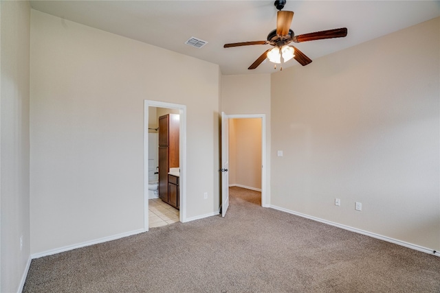 unfurnished bedroom with ensuite bath, ceiling fan, and light carpet