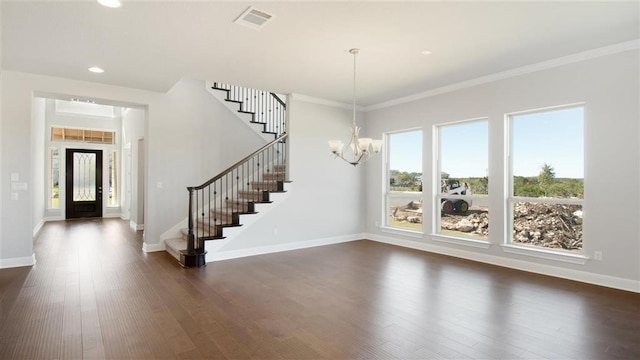 foyer entrance featuring a chandelier, ornamental molding, a wealth of natural light, and dark wood-type flooring