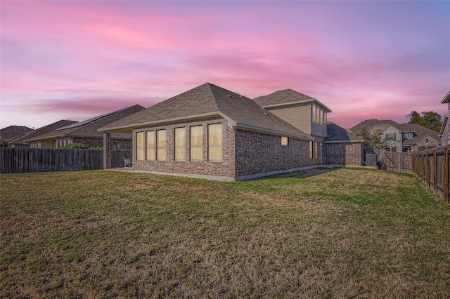 back house at dusk with a yard