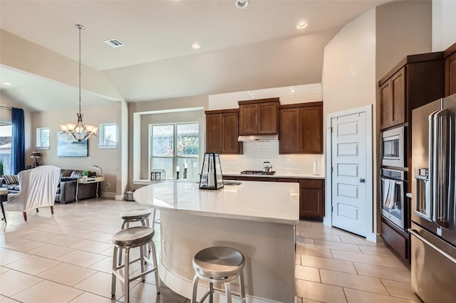 3317 Nighthawk Dive Ln, Pflugerville, TX 78660 - kitchen featuring stainless steel appliances, lofted ceiling, a breakfast bar area, light countertops, and backsplash