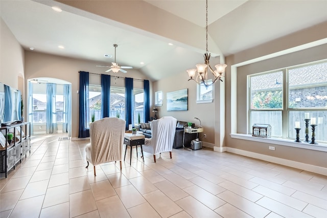 dining area with ceiling fan with notable chandelier and lofted ceiling