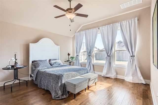 bedroom with ceiling fan, hardwood / wood-style floors, and vaulted ceiling