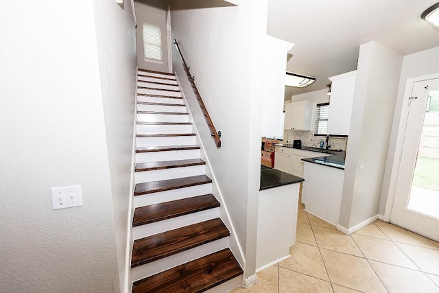 stairs featuring sink and tile patterned floors