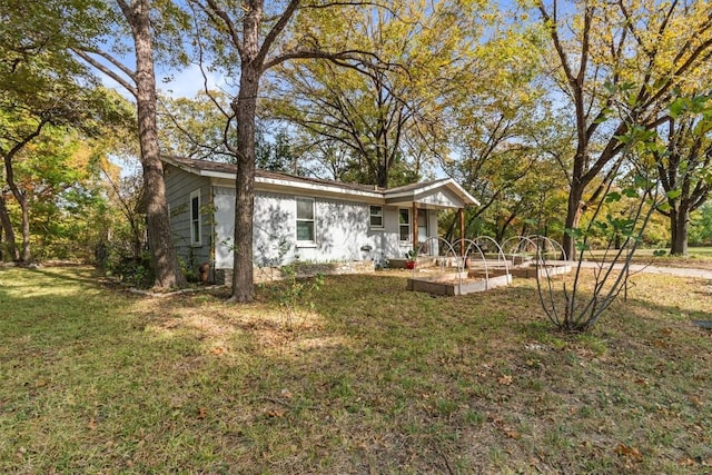 view of front of property featuring a vegetable garden and a front lawn