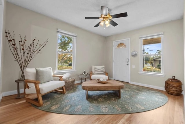 sitting room featuring wood finished floors, baseboards, and ceiling fan