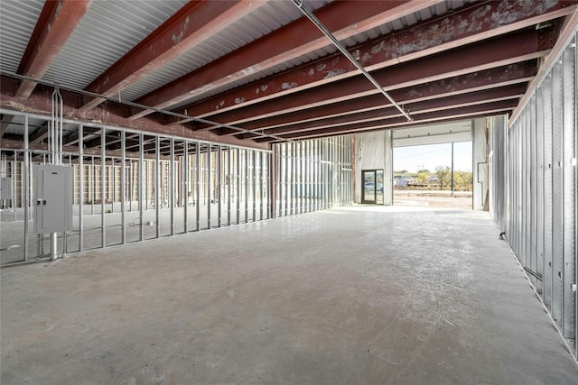 misc room with electric panel and concrete floors