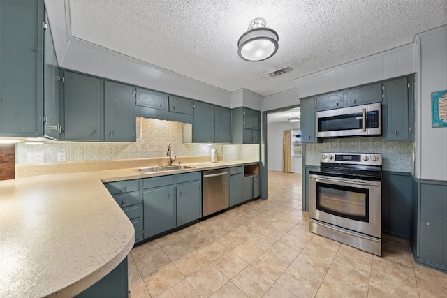 kitchen featuring a textured ceiling, stainless steel appliances, and sink