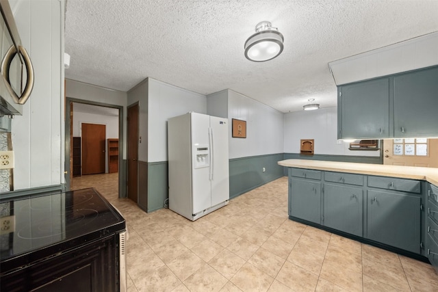 kitchen featuring white refrigerator with ice dispenser, a textured ceiling, and range