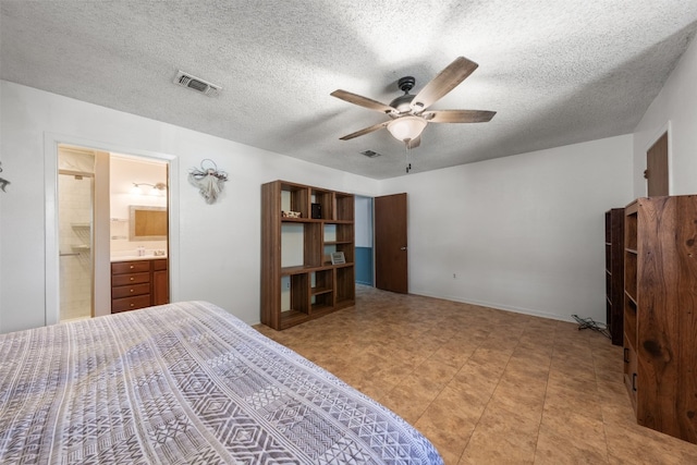 bedroom with ensuite bath, ceiling fan, and a textured ceiling