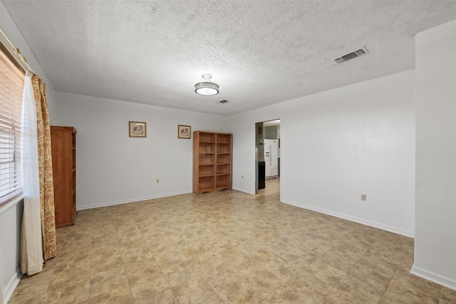 unfurnished room with a textured ceiling