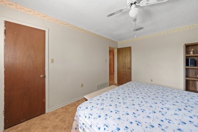 bedroom with ceiling fan and a textured ceiling