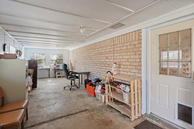 misc room with concrete flooring and brick wall