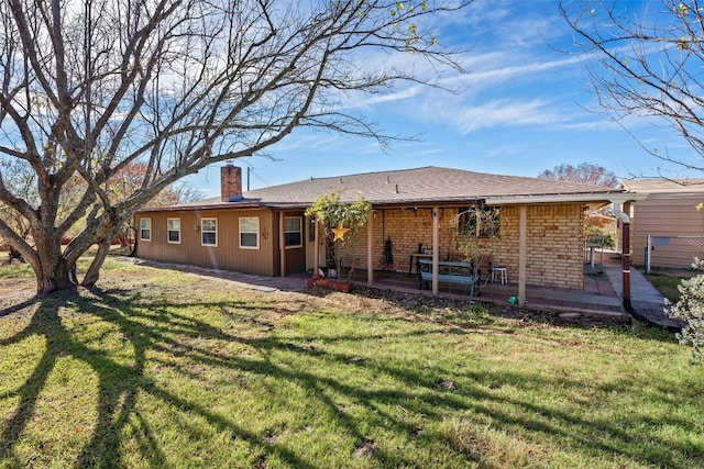 rear view of property featuring a yard and a patio