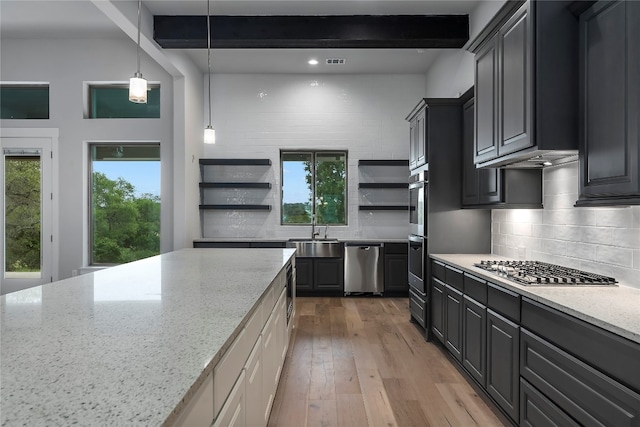 kitchen featuring light hardwood / wood-style floors, light stone counters, and plenty of natural light