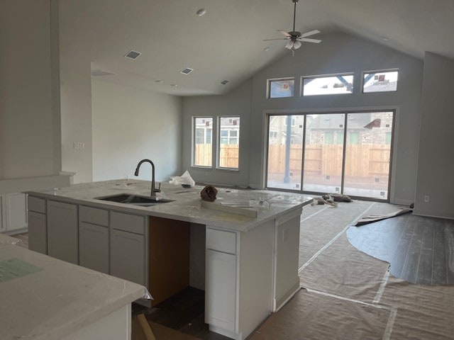 kitchen with white cabinetry, a kitchen island with sink, sink, and dark hardwood / wood-style floors