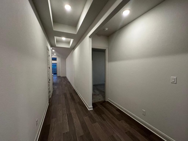 hallway featuring dark hardwood / wood-style floors and a raised ceiling