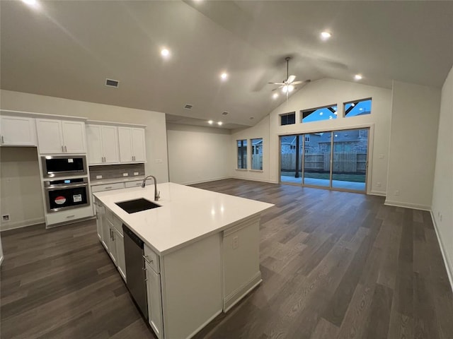 kitchen with an island with sink, sink, white cabinets, dark hardwood / wood-style flooring, and stainless steel appliances