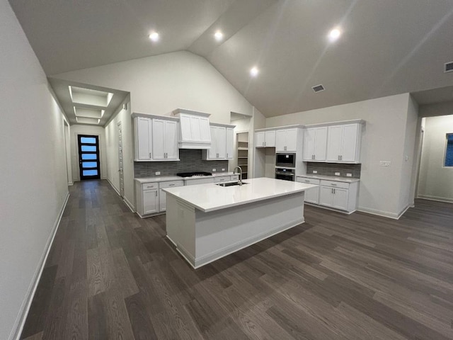 kitchen featuring black gas cooktop, white cabinetry, an island with sink, sink, and stainless steel oven