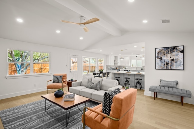 living room with vaulted ceiling with beams, ceiling fan, and light hardwood / wood-style floors