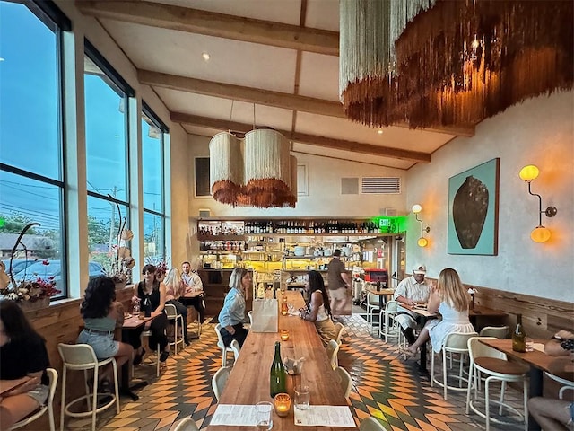 dining space featuring lofted ceiling with beams