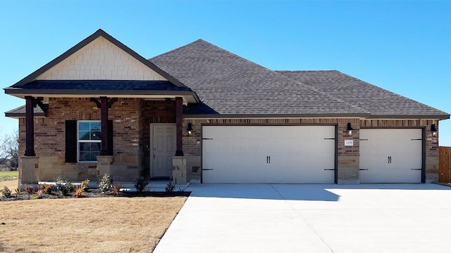view of front of house featuring a garage, roof with shingles, brick siding, and driveway