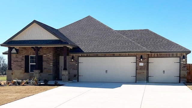 view of front of property featuring brick siding, an attached garage, a shingled roof, and driveway