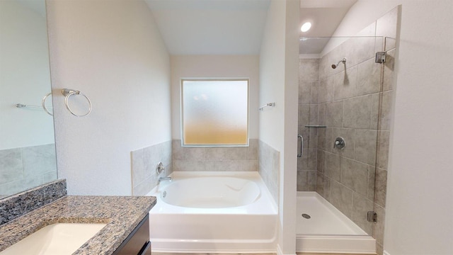 bathroom with a shower stall, a garden tub, lofted ceiling, and vanity