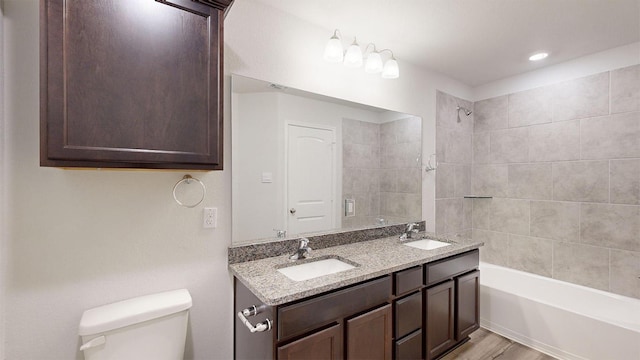 bathroom with shower / washtub combination, a sink, double vanity, and toilet